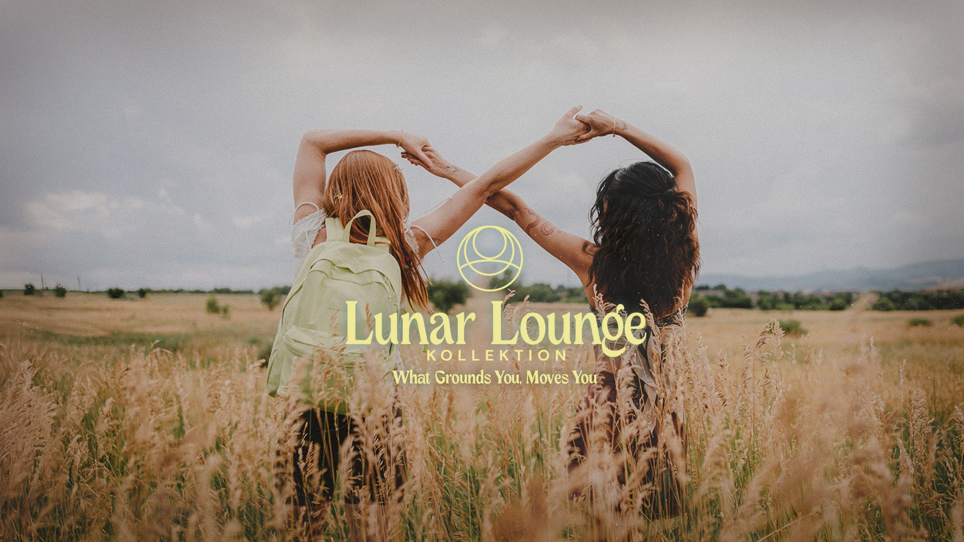 
Zwei Personen mit erhobenen Armen auf einem Feld, daneben das Jansport Lunar Lounge-Logo.